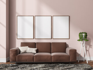 Three canvases on pink wall and brown coach in living room