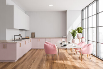 Light kitchen interior with table and chairs on parquet floor near window