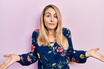 Young caucasian woman wearing casual clothes clueless and confused expression with arms and hands...