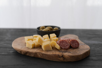 antipasti on olive board on black wood table