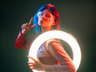 Neon light model. Techno style. Futuristic illumination. Flirty cute woman pouts lips with LED...