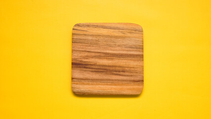 round wooden cutting Board top corner isolated on yellow background