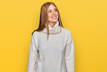 Young irish woman wearing casual winter sweater looking away to side with smile on face, natural expression. laughing confident.