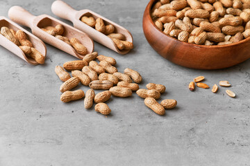 Image of wooden spoons with peanuts on a concrete surface