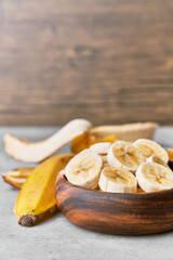 Photo of banana slices in a bowl on a concrete surface