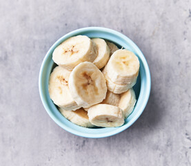  Bowl of slices of banana on a concrete surface