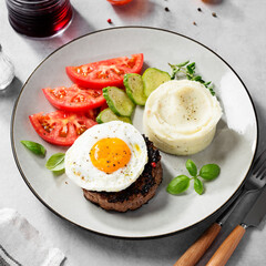 Juicy Chopped steak with fried egg, mashed potatoes and tomato slices.	
