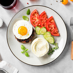 Juicy Chopped steak with fried egg, mashed potatoes and tomato slices. top view	

