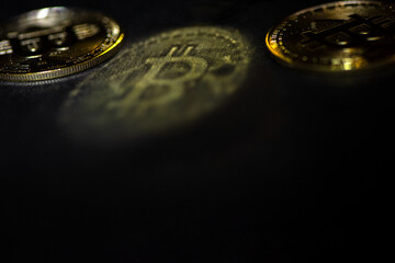 Golden bitcoin reflection on dark surface