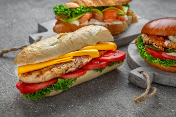 Sandwich, burger and croissant. Delicious healthy snack with meat, fish, vegetables and herbs. Fast food for take and go restaurant. Food delivery