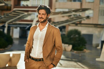 Fototapeta premium Young hispanic businessman smiling happy standing at the city.