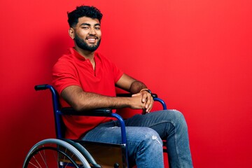 Arab man with beard sitting on wheelchair with a happy and cool smile on face. lucky person.