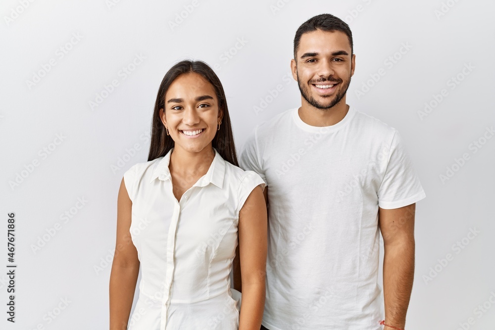 Canvas Prints young interracial couple standing together in love over isolated background with a happy and cool sm