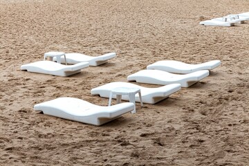 Empty sun beds at the beach of the hotel in relief of the epidemic
