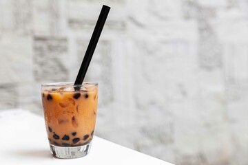Thai tea with milk in a glass jar placed on a wooden table