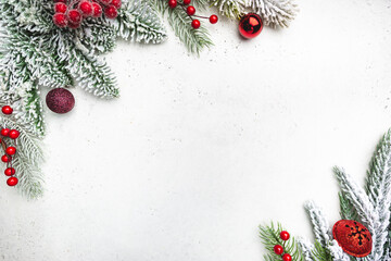 Christmas holidays composition with snowed fir tree branches and red decorations on white...
