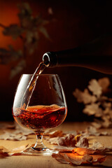Cognac is poured into a glass from a bottle.