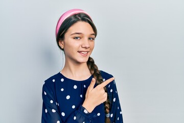 Young brunette girl wearing elegant look cheerful with a smile of face pointing with hand and finger up to the side with happy and natural expression on face