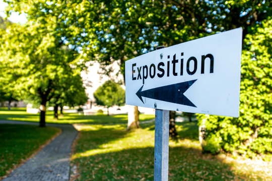 Panneau de signalisation d'une exposition avec fl&egrave;che dans un parc arbor&eacute;