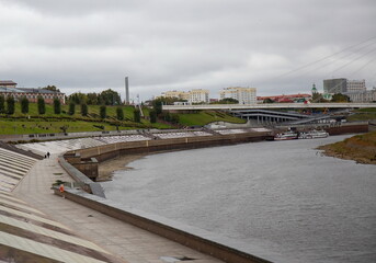 View from the granite embankment to the bridge of lovers in the city of Tyumen in autumn
