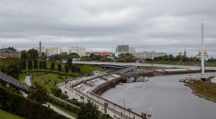 Fototapeta na wymiar View from the granite embankment to the bridge of lovers in the city of Tyumen in autumn