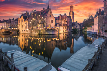Historic medieval buildings along a canal in Bruges during amazing sunset, Belgium