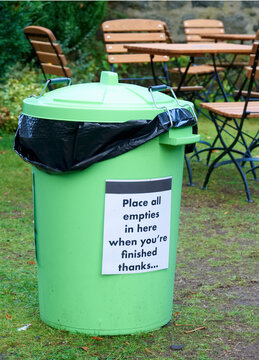 Green bin at outdoor cafe for garbage collection to keep area clean
