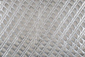 smooth surface of quilted jacket fabric of silver color, background, texture