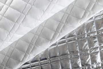 silver-colored quilted jacket fabric, neatly folded