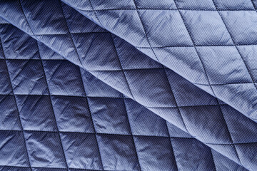 blue quilted jacket fabric with stripes, neatly folded in folds