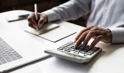 Man accountant using calculator and computer in office, Business accounting, bills, home budget, tax, savings, finances, economy, audit, debt concept - obrazy, fototapety, plakaty