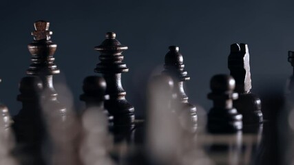 Board intelligence game - wooden chess. Close- up view of pieces on chessboard rotating clockwise on dark background. Business solutions, challenge, sport, success strategy concept.