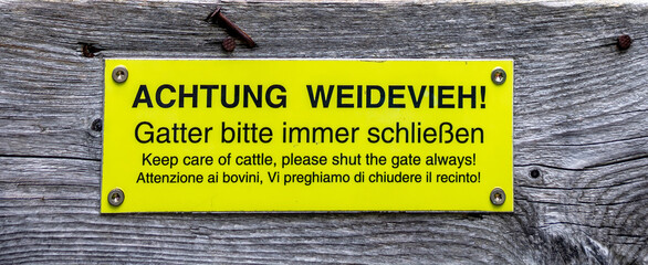 Yellow Sign, On Wooden Fence With Written Advice With Text "Keep Care Of Cattle, Please Shut The Gates Always!"