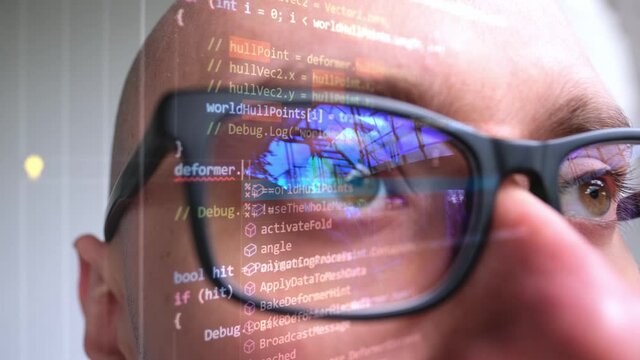 Close-up Face Of A Young Man Wearing Glasses, Reflection Of A Dark Screen With Source Code, The Concept Of Creating Computer Programs, Software, Programming, Using Cyberspace