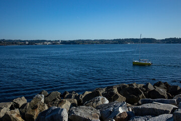 A yellow boat sails on a clear day without sails