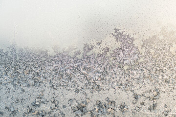 frozen lite golden snowflakes on the window on a frosty day in winter