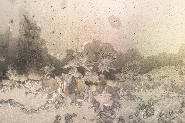 yellow-gold background of frozen patterns on the window in the frost in the sun