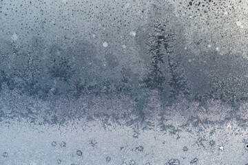 Fototapeta na wymiar frozen patterns of water from frost on the window - like fir trees after a snowstorm in winter