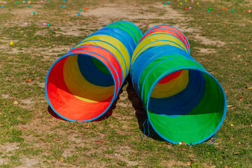 Two colorful toy tunnels for children on the grass.