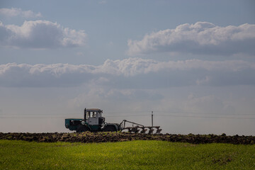 Naklejka premium Farmer in tractor preparing land with seedbed cultivator