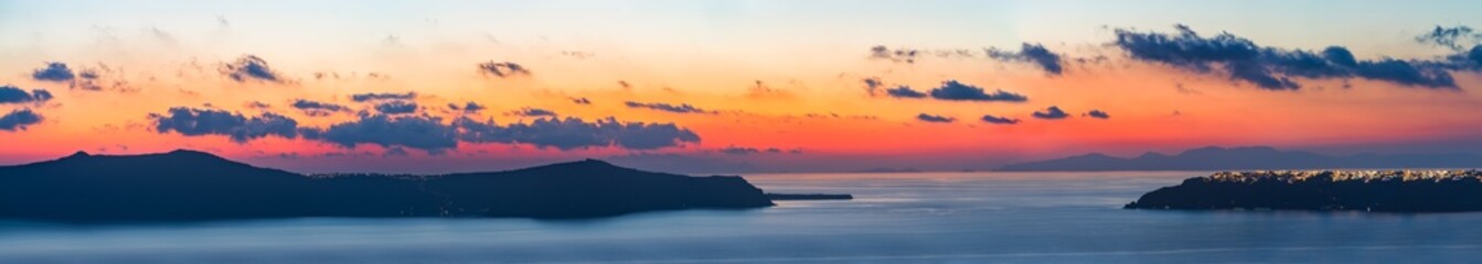 Nea Kameni island and Oia village at sunset in Santorini. Greece