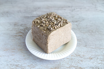 halva from sunflower seeds on a white plate. national traditional sweetness of turkish halva on the table. High quality photo