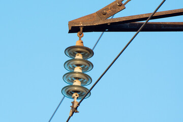 Electrical insulator of high-voltage electric line against the blue sky.