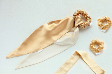 golden silk scrunchy flat lay on white. Hairdressing tools and accessories. luxury ladyes hair scarf