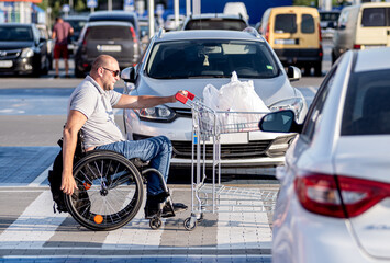 Person with a physical disability pushing cart in front of himself at supermarket parking