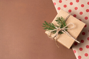 Gift kraft box with christmas decoration made of fir branches on paper background for gift wrapping. Copy space
