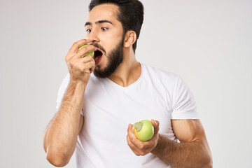 Cheerful man with apples in his hands in a white t-shirt fruits