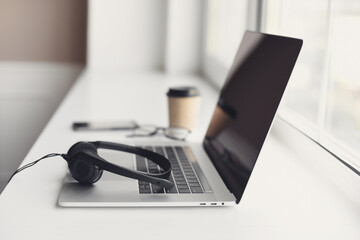 Workplace, laptop computer and headset at office desk, modern business lifestyle, online learning,...