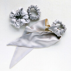silver silk Scrunchy on white. Flat lay Hairdressing tools and accessories. Luxury Elastic Hair Band