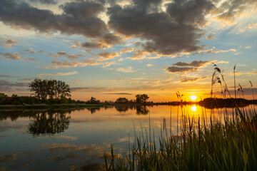 Fototapeta na wymiar Beautiful sunset over a calm lake, summer day